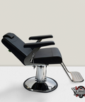 A black, upholstered salon chair with chrome base and armrests, and a footrest attached underneath. The chair is branded with 'JV Beauty'.